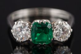 A platinum, emerald and diamond three-stone ring: with central 'emerald-cut' emerald 6mm long x 5.