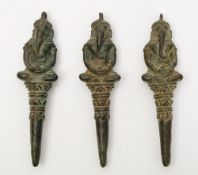 Three Khmer 13th century post Bayon bronze pendants: of Ganesha seated cross legged on tapering