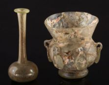 A Byzantine pale green glass lamp and a Roman pale green glass unguentarium: the lamp with central