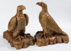 A pair of North Devon saltglazed stoneware eagles: with folded wings perched on a naturalistic base,