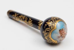 A Continental porcelain two-piece parasol handle: the globular handle joined to a narrow shaft