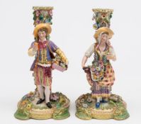 A pair of Minton figural candlesticks: in the form of girl and youth flower and fruit sellers,