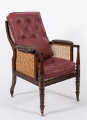 A Regency mahogany bergere armchair: with curved cane panel back, sides and seat,