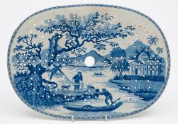 An unattributed pearl glazed transfer decorated blue and white decorated strainer: of oval form and