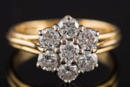 An 18ct gold and diamond seven-stone circular cluster ring: with circular,