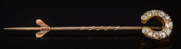 A late 19th century gold and diamond mounted horseshoe stick-pin: with graduated round old