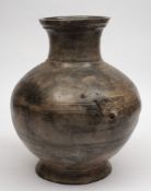 A large Chinese grey pottery jar: of baluster form with incised geometric bands and taotie mask