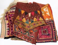 A collection of Indian and Middle Eastern wall hangings:, with stitched geometric decoration.