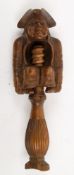A 19th century continental treen nutcracker in the form of a seated man:,(split along grain ,