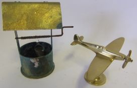 A World War I trench art shell in the form of a wishing well: and a brass model of a Spitfire.
