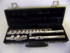 A Buffet Champion three section flute: contained in a fitted carrying case.