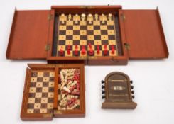 An early 20th century mahogany folding chess set with turned ivory pieces and one other smaller:,