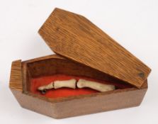 A small oak box in the form of a coffin containing three phalanges:.