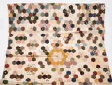 An early 19th century patchwork quilt:, hand stitched from hexagons of various materials,
