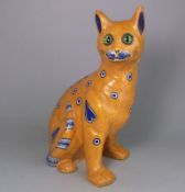 A Mosanic pottery cat: in seated posture with curled tail with inset glass eyes,