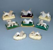 A group of eight Staffordshire porcelain figures of poodles: comprising a matched pair of a bitch