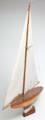 A model pond yacht, circa 1940's:, fully rigged over a laminated hull with shaped weighted keel,