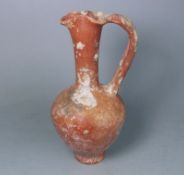A 1st century Mediterranean terracotta ewer: of footed oviform with slender raised neck,