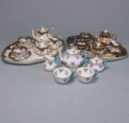 Two Crown Staffordshire miniature porcelain cabaret sets: each comprising a tray, teapot and cover,