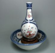 A porcelain bottle vase and matching bowl: enamelled in the famille rose palette with flowers and a