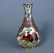 A Zsolnay Pecs pottery vase: of pear shaped form decorated with two panels of pink storks reserved