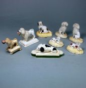 A group of eight porcelain dog figures: comprising a pair of Samuel Alcock seated poodles and two