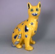 A Mosanic pottery cat: in seated posture with curled tail with inset glass eyes,