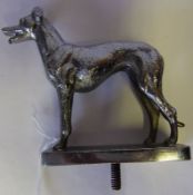 A chrome car mascot in the form of a greyhound: mounted on a rectangular base, 10cm. high.