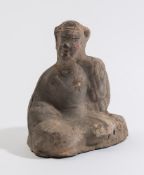 A Chinese pottery seated dignitary: with left arm raised and head turned,