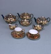 A Derby porcelain miniature tea service in the Witches pattern: comprising three circular tea pots