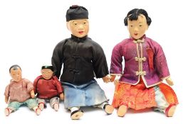 An early 20th century family of four Chinese dolls:, each with painted faces and hands,
