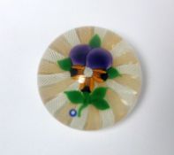 A John Deacons glass paperweight: with central flower and leaves set on a cushion of radiating