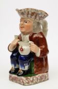A pottery toby jug: modelled as a seated toper in tricorn hat,