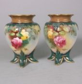 A pair of Royal Worcester porcelain vases: of egg shaped form with four peg feet,