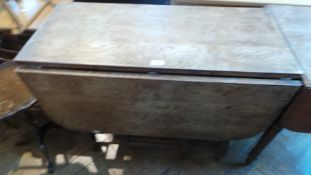 An old oak gateleg dropleaf dining table on turned supports,