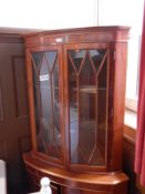 A mahogany walnut bow front corner cupboard, with dentil frieze,