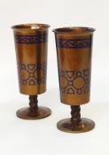 Pair of bronze pedestal vases painted gold with blue enamel geometric and scroll decoration,