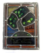 Stained and leaded glass panel depicting a tree and inscribed 