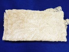 A pair of patterned curtains, a large crocheted bed throw,