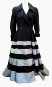 A Jasper Conran black coat dress, full skirted, the skirt banded in silver-coloured material,