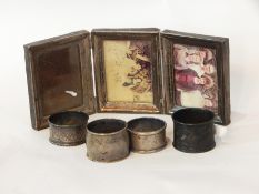 A Mexican 925 silver folding triple photograph frame together with four white metal napkin rings,