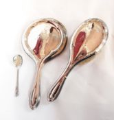 A George V silver-backed dressing table set comprising hand mirror and hair brush,