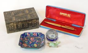 A small square dish with floral decoration, a glass paperweight,