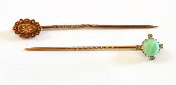 A jade and diamond stickpin set centre polished cabochon jade and having surround of four tiny