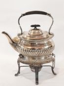 A silver plated tea kettle with burner, gadrooned, on four supports,