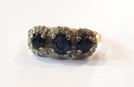 A diamond and sapphire half-hoop ring set three facet-cut sapphires,