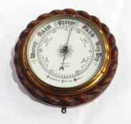 A carved oak aneroid barometer of ropetwist design, cased, white enamel dial, inscribed 