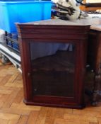 A 19th century mahogany corner cupboard, the glazed panel door enclosing shelf,