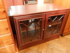 A glazed fronted television cabinet with one shelf