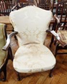 An open armchair with white floral cushion covers